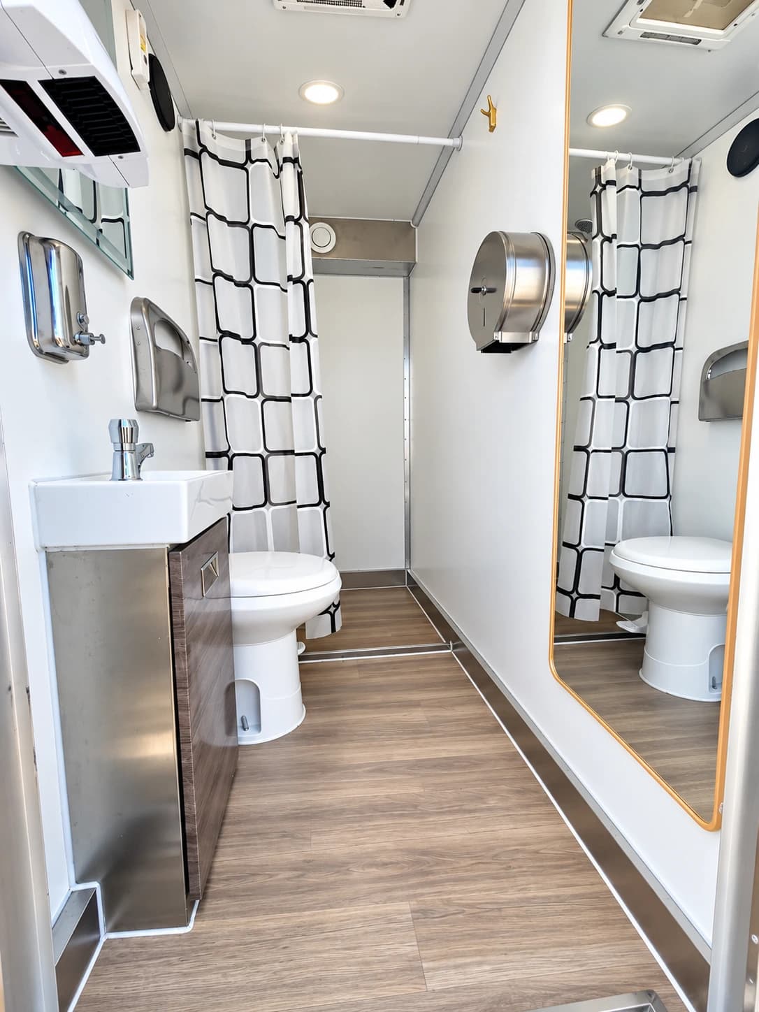 Shower and restroom trailer with sinks along an interior aisle