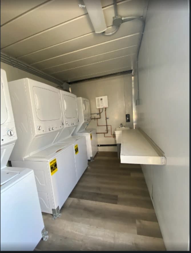 Container laundry room with washers and dryers along an aisle